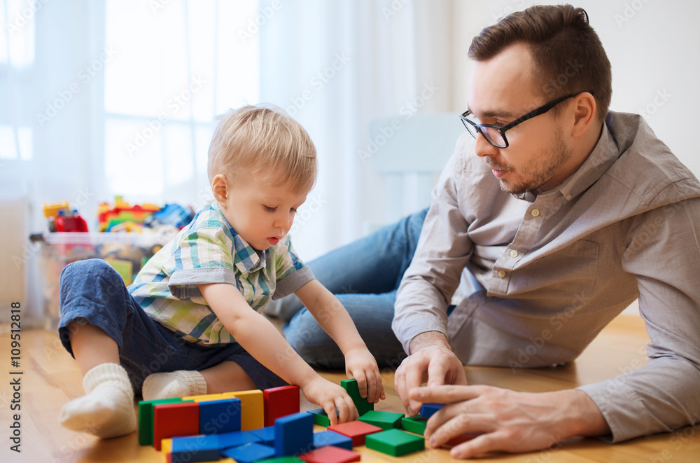 father and son playing with toy blocks at home