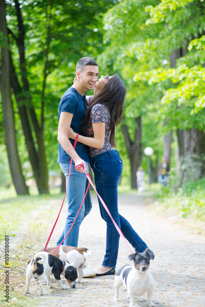Young couple in love,walking and enjoy in park with his dogs Young couple in love,walking and enjoy in park with his dogs