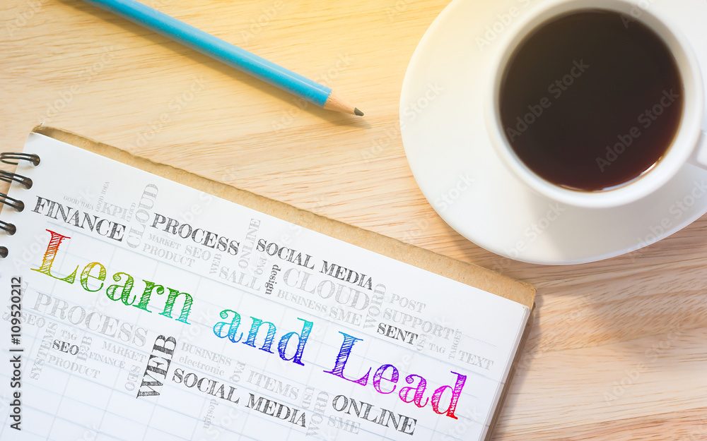Concept Learn and Lead message on book. A pencil and a glass coffee table.Vintage tone. Concept Learn and Lead message on book. A pencil and a glass coffee table.Vintage tone.