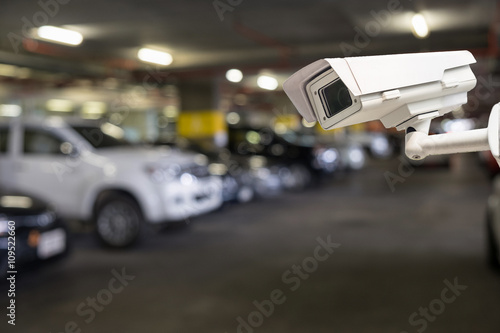 Fototapeta Naklejka Na Ścianę i Meble -  CCTV security camera on blur car parking