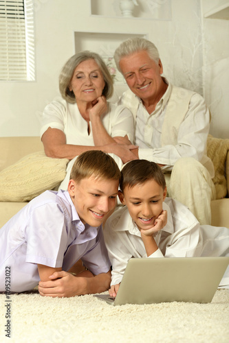 Happy family with kids with laptop