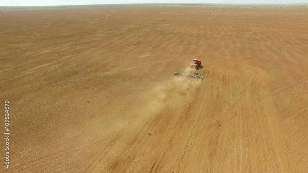 Aerial footage of vintage harvester, harvesting hay paddock in rows ...