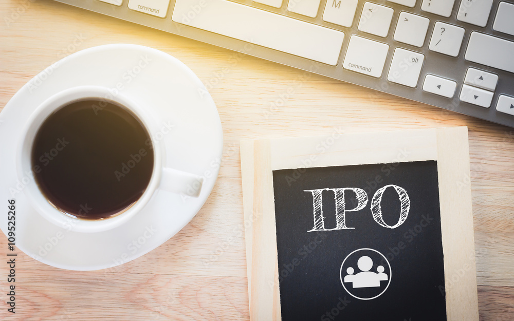 Concept IPO message on wood boards. A keyboard and a glass coffee table.Vintage tone. Concept IPO message on wood boards. A keyboard and a glass coffee table.Vintage tone.