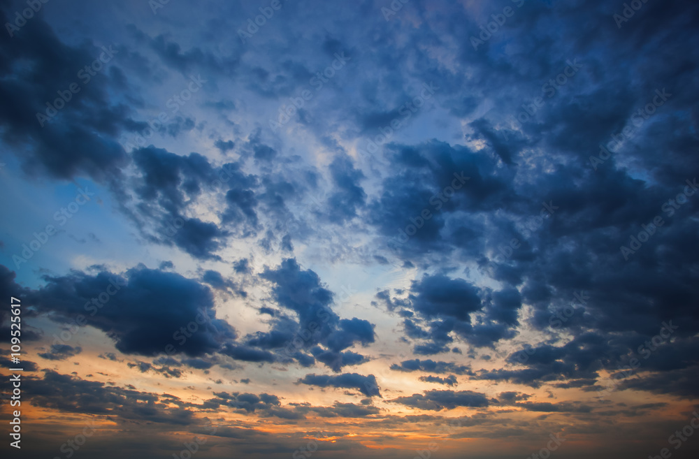 Big blue clouds on the sunset background.