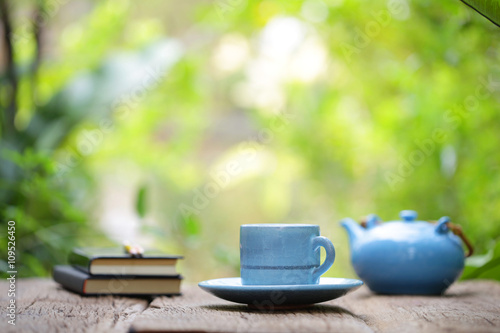 blue vintage cup with pot and notebook on wood table 