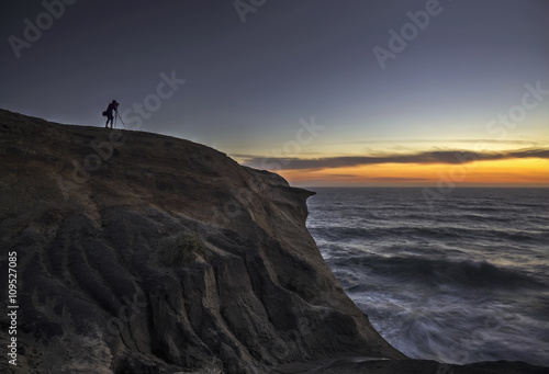 Photographer at the top of the cliff at Cape Kiwanda, Oregon.