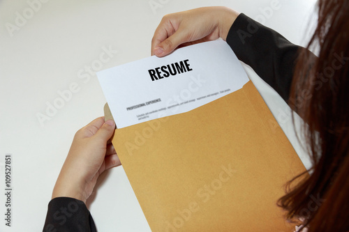 Businesswoman opening resume in letter envelope