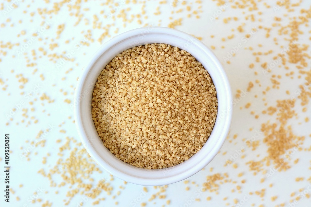 Wholegrain couscous in the bowl on the white background Wholegrain couscous in the bowl on the white background