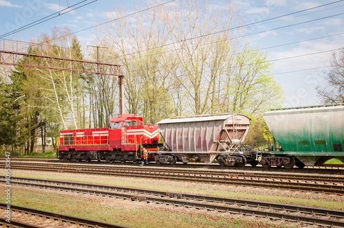 attached diesel locomotive is pulling freight wagons, spring