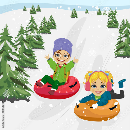 little boy and girl sliding down hill on tubes