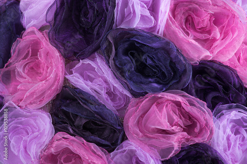 Background of pink and purple blossoms from cloth. Background of artificial roses.