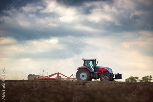 Fototapeta Naklejka Na Ścianę i Meble -  Farmer in tractor preparing land with seedbed cultivator