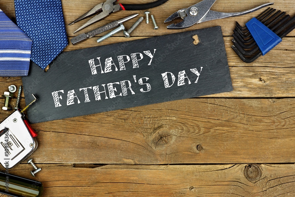 Happy Father's Day written on slate with corner border of tools on old ...