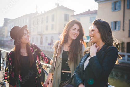 Three young women chatting on canal waterfront photo