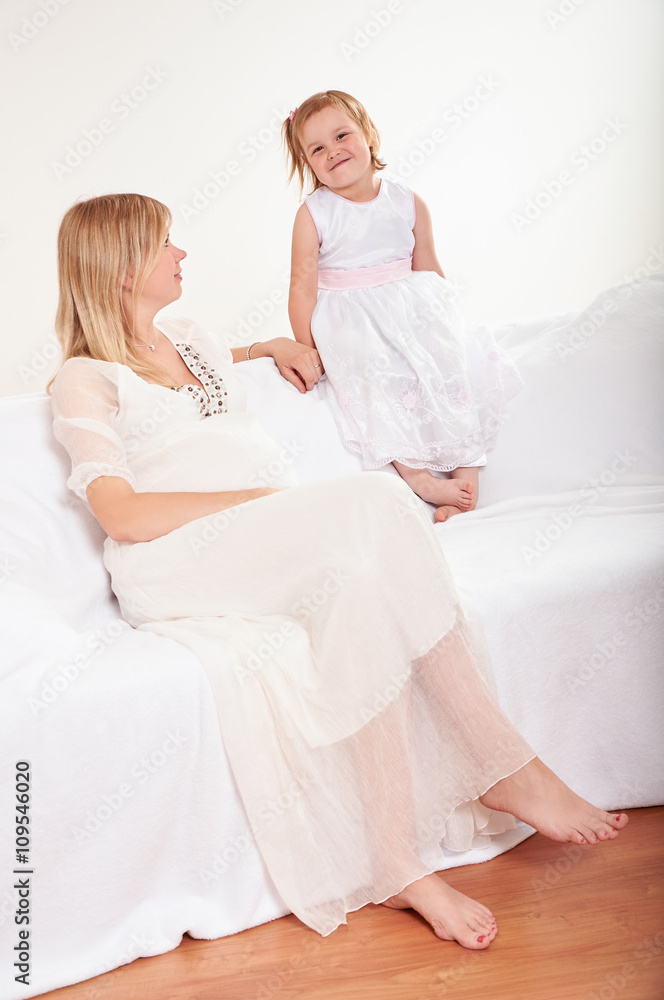 Young pregnant woman with little daughter 