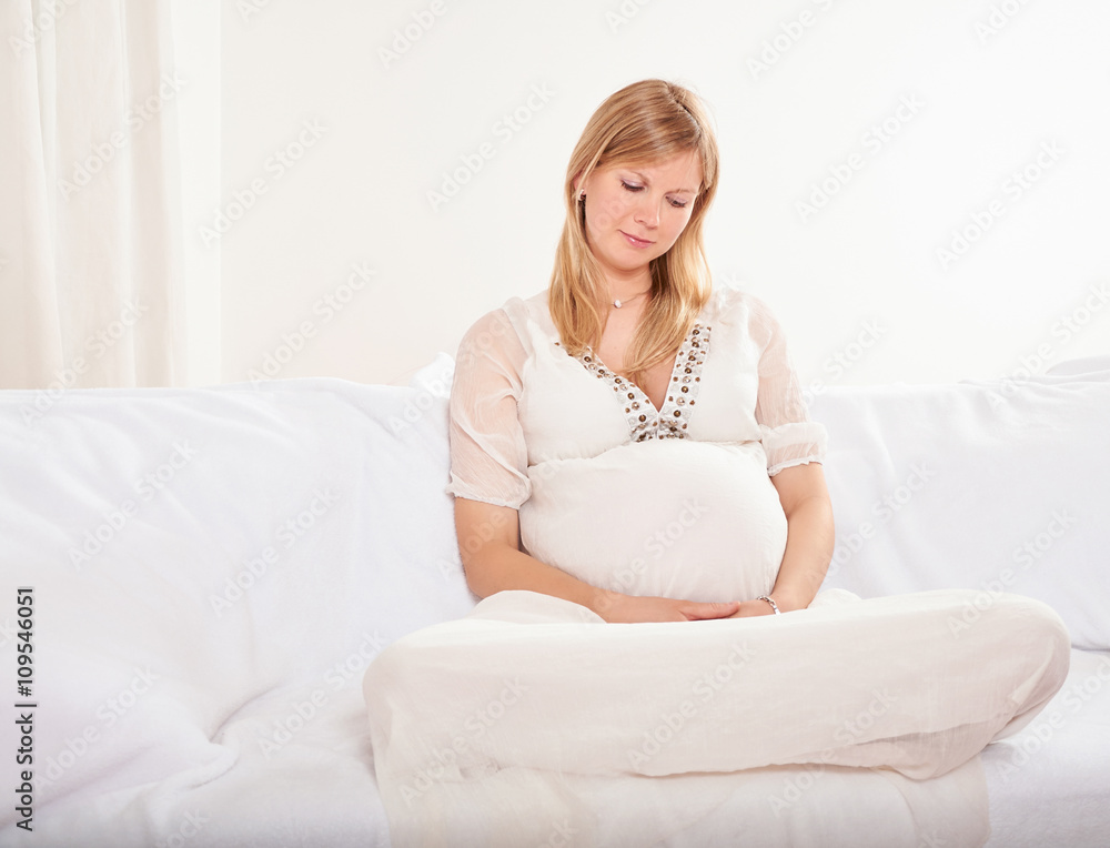 Pregnant woman relaxing at home on the couch Pregnant woman relaxing at home on the couch