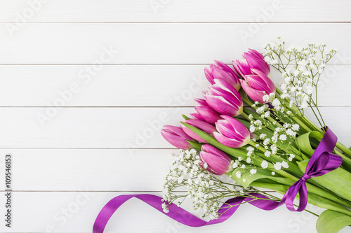 Fototapeta Naklejka Na Ścianę i Meble -  Pink tulips bouquet on white wooden background. Copy space, top view. Holiday background