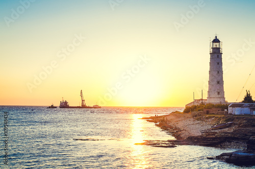 The lighthouse on sunset beach. 