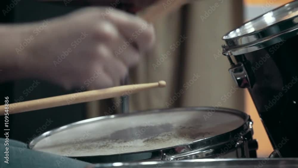 Musician playing drums at studio, close up, slow motion