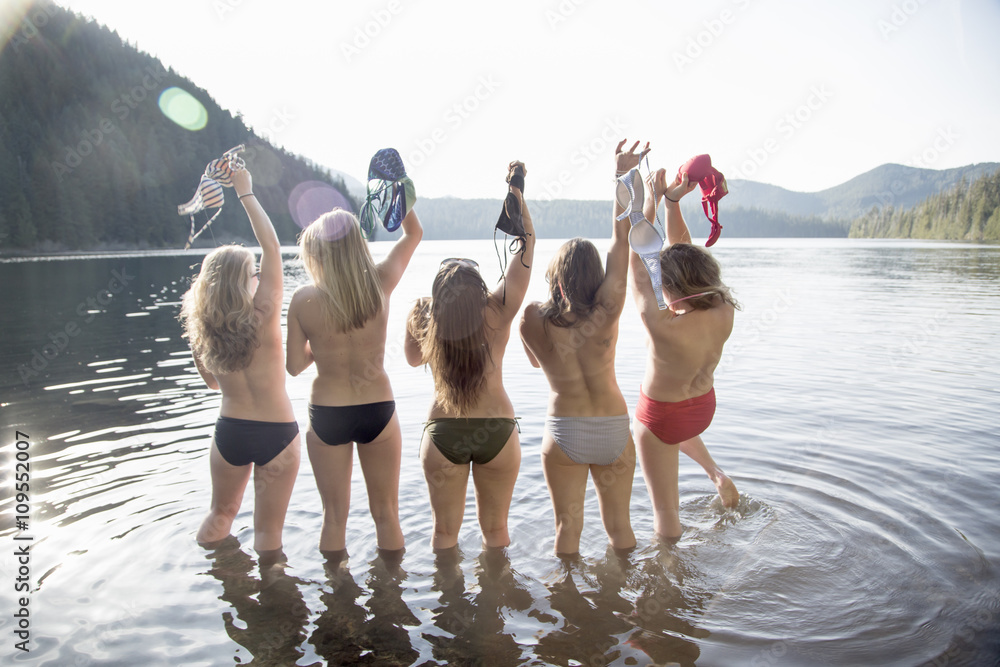 Young women taking off bikini tops, Lost Lake, Oregon, USA Stock