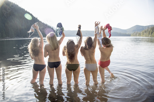 Young women taking off bikini tops, Lost Lake, Oregon, USA