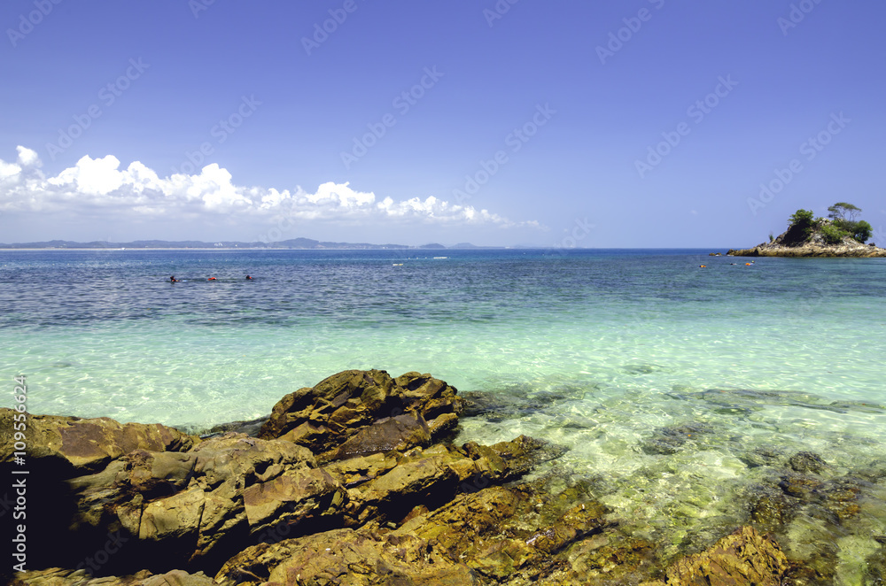 Fototapeta premium scenic sea view of the Kapas Island at Terengganu, Malaysia. Clear sea water and blue sky background. Rocky island and cloudy sky at sunny day.