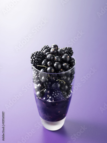 Ingredients in drinking glass for blackcurrant and blackberry fruit juice