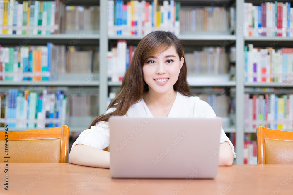 young beautiful asian girl with laptop in school library young beautiful asian girl with laptop in school library