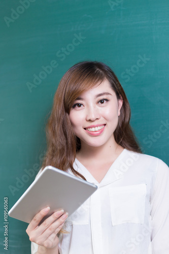 beautiful young girl with green blackboard in classroom