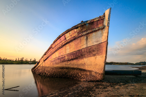 Abandoned Ship during sunset moment at sabah borneo malaysia Image has grain or blurry or noise and soft focus when view at full resolution.  Shallow DOF  slight motion blur 