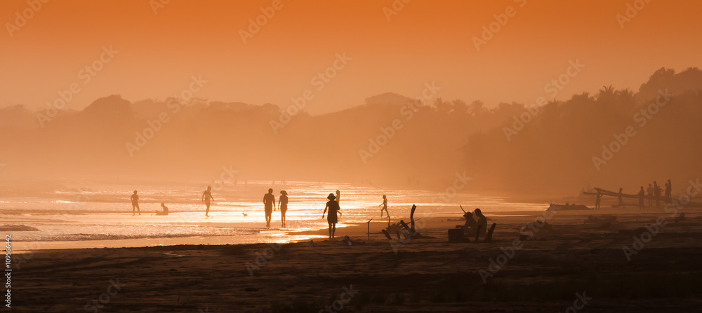 Beautiful sunset beach panorama with silhouettes of tourists and bathers people. Central America. Costa Rica