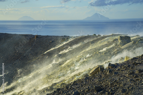 Sulphur and fumaroles smoke on Gran Cratere; The Islands of Alicudi and Filicudi in the background, Vulcano Island, Aeolian Islands, Sicily, Italy