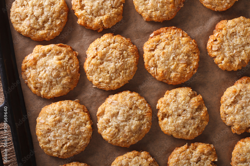 Freshly baked oatmeal Anzac cookies close up on a baking sheet. Horizontal top view
Freshly baked oatmeal Anzac cookies close up on a baking sheet. Horizontal top view