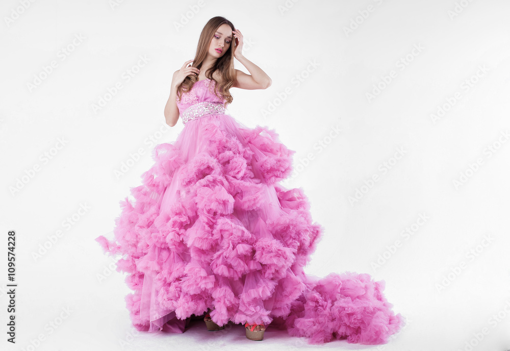 Portrait of young beautiful caucasian blonde in gorgeous pink dress on white background Portrait of young beautiful caucasian blonde in gorgeous pink dress on white background