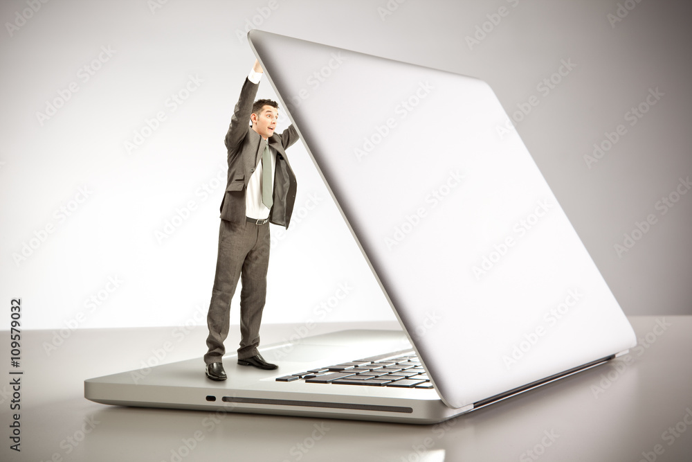 Little surprised businessman opening laptop cover at office Little surprised businessman opening laptop cover at office