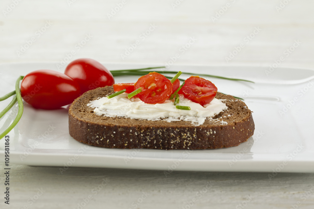 slice of chocolate loaf with butter and cherry tomato