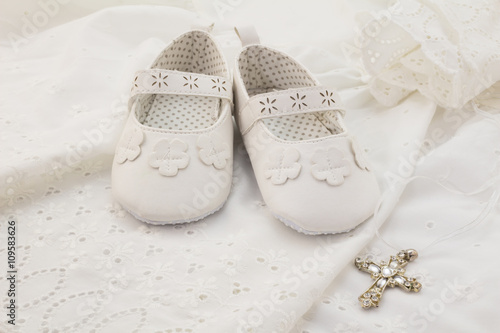 Baby christening white shoes with cross pendant on white