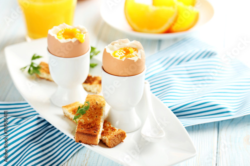 Boiled egg with toasts on a blue wooden table