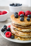 Pancakes with blueberries and raspberries on rustic wood
