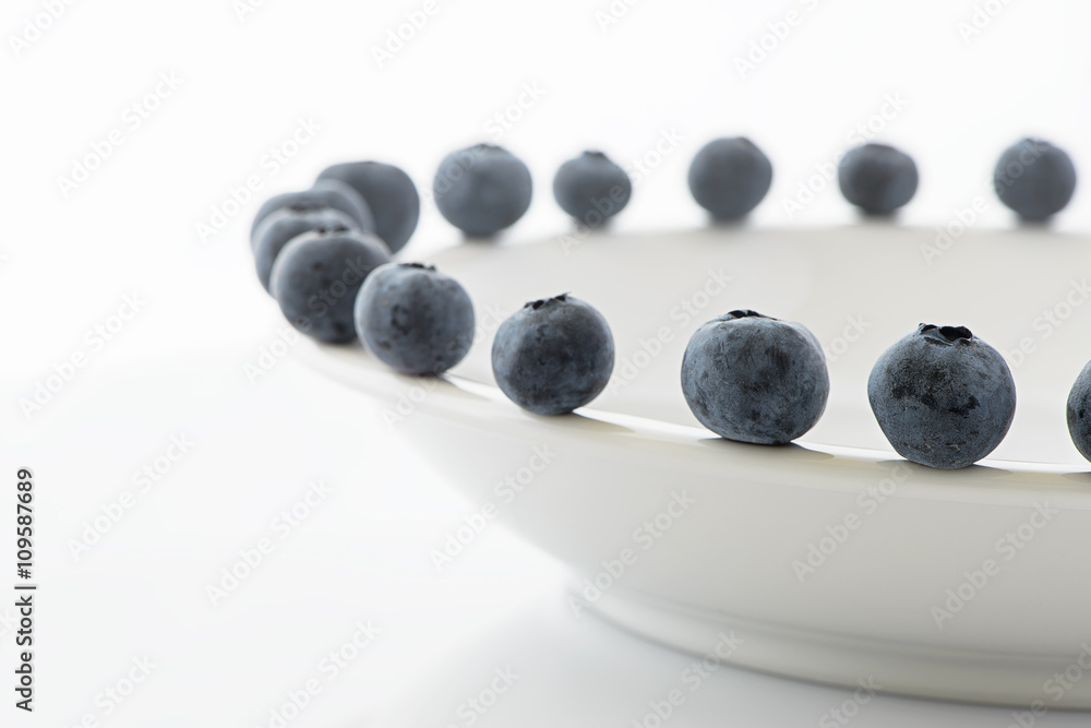 Frresh blueberries closeup on a white plate Frresh blueberries closeup on a white plate