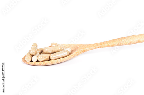 Capsules of herbs on spoon. healthy eating for healthy photo