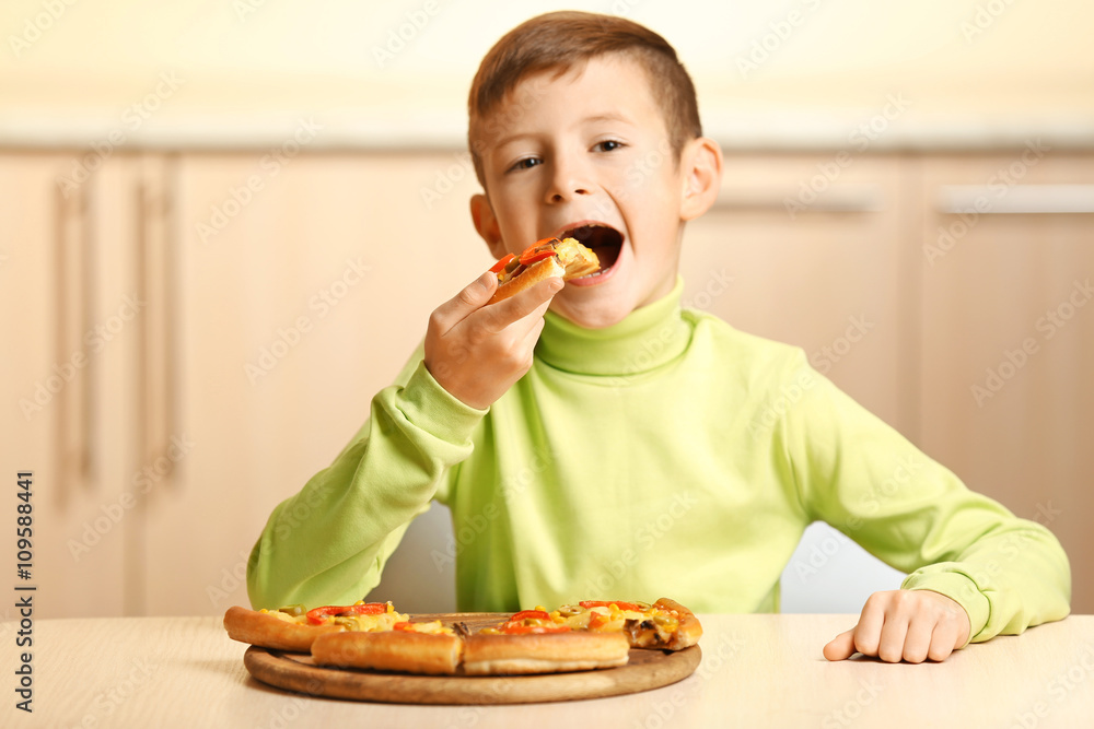 Little boy eating pizza at home Little boy eating pizza at home