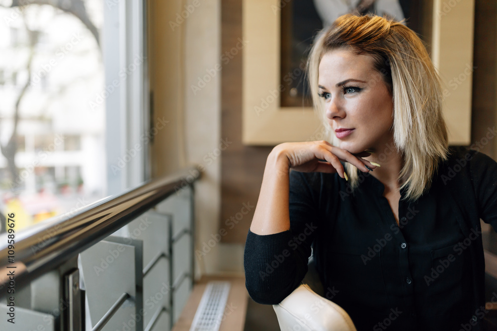 Blonde businesswoman looking out the window Blonde businesswoman looking out the window