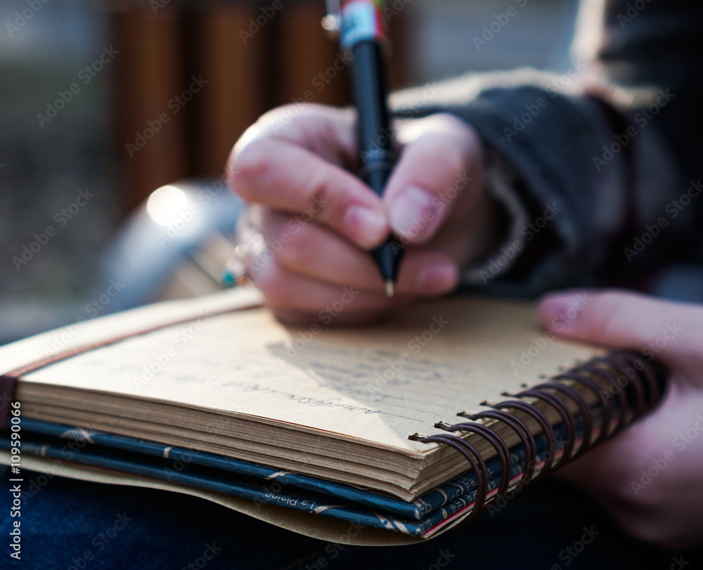 person writing in a notebook person writing in a notebook