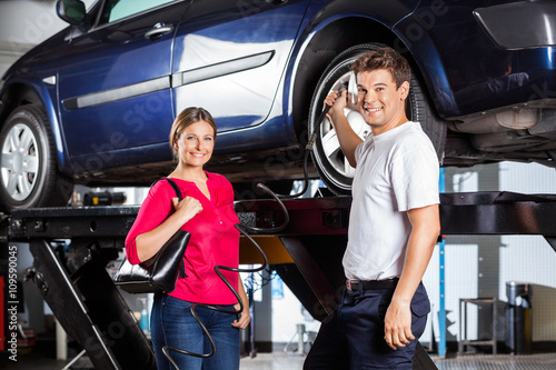 Customer Standing With Mechanic Filling Air In Tire © Tyler Olson