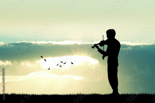 Man playing the violin at sunset