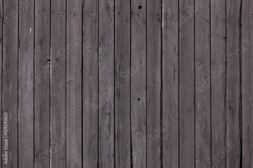 fence of vertical old brown purple planks or side of shed