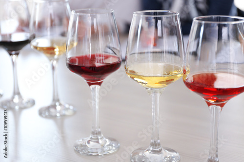 Many glasses of different wine in a row on a table. Tasting wine concept