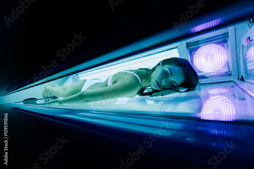 Beautiful woman tanning in solarium