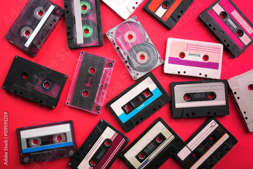 Set of old audio cassettes on red background